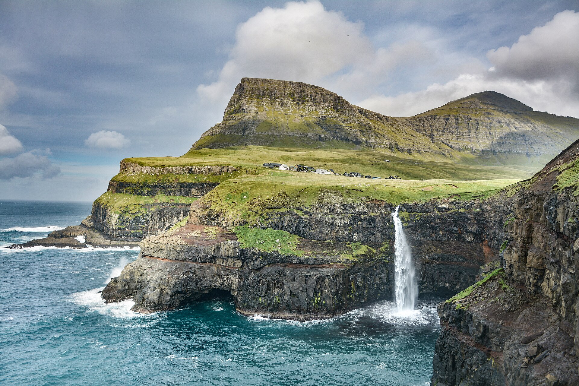 Falaises verdoyantes plongeant dans l'océan aux îles Féroé